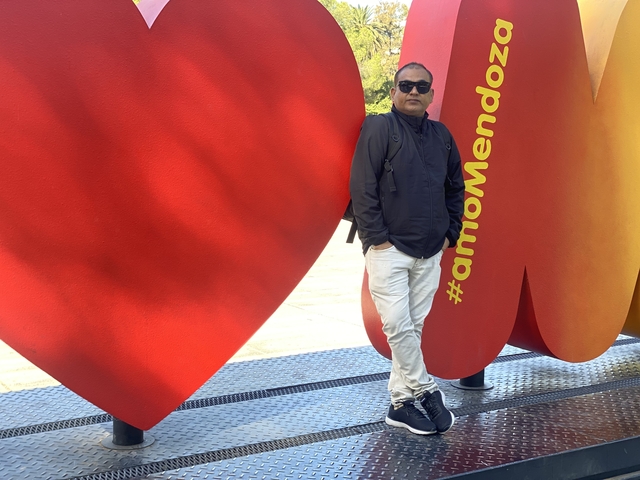 A man standing in front of a colorful hashtag sign.