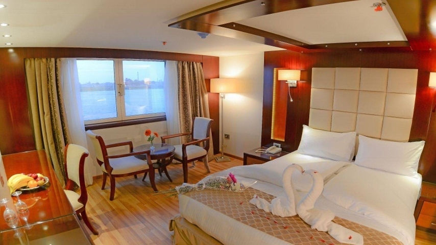 Luxurious hotel room with a view of a river through a window.