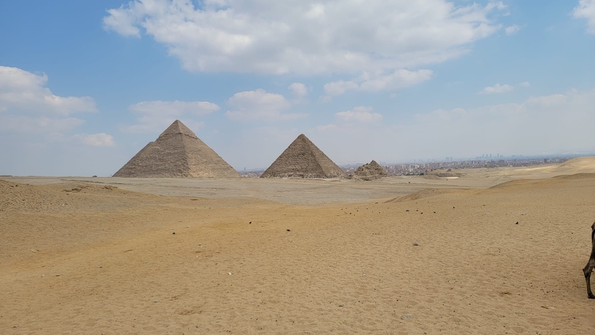 View of three pyramids on a desert landscape.