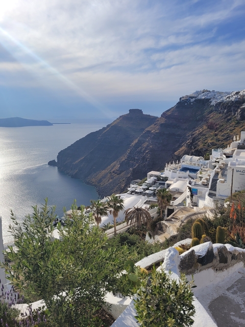 Santorini-style buildings on a cliff overlooking the sea.