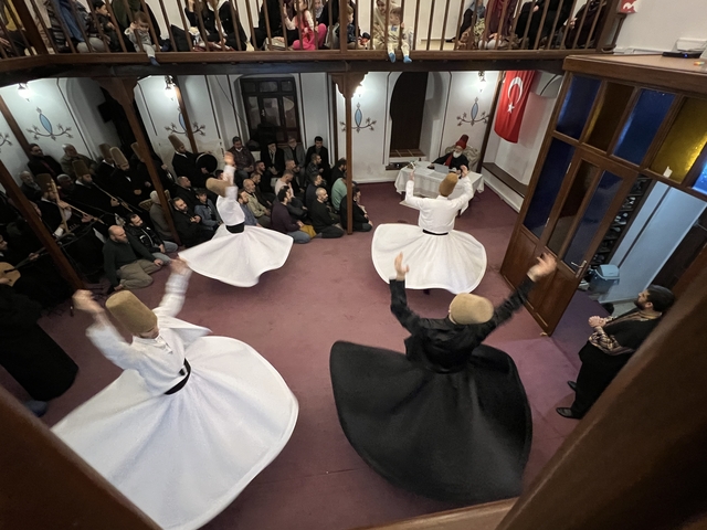 Traditional Sufi dancers performing in a hall with an audience.