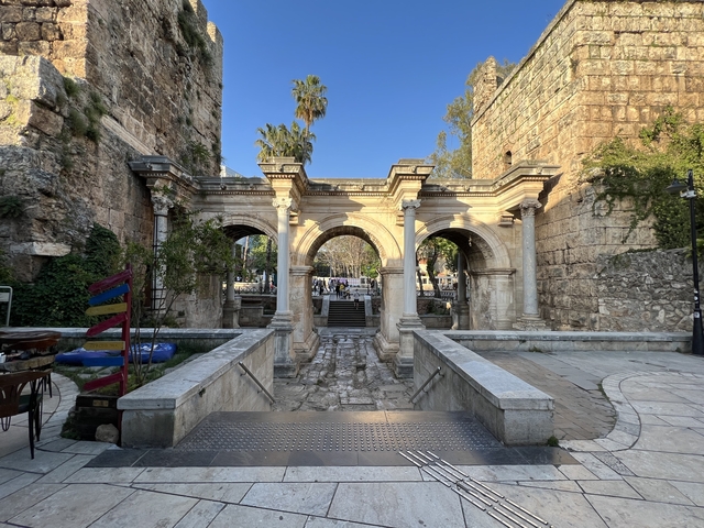 Historic gates with arches in a scenic city setting.