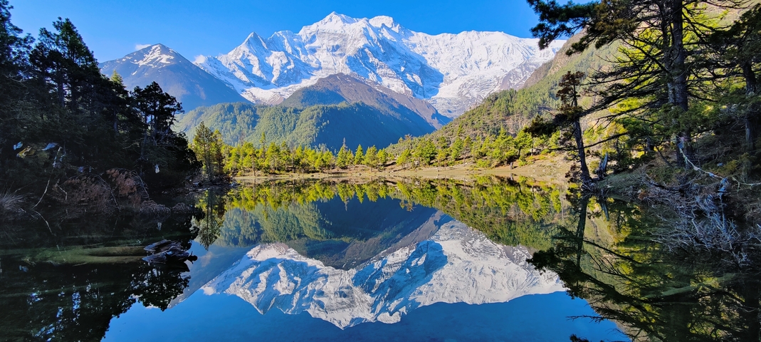 Stunning reflection of snow-capped mountains in a clear lake.