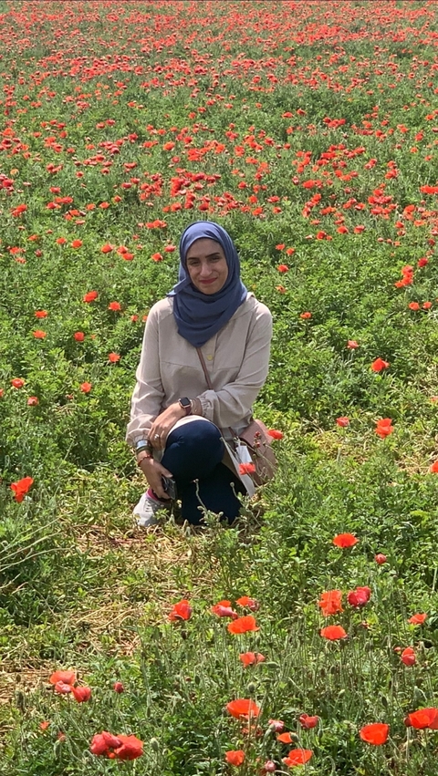       Person posing in a field of flowers.
  