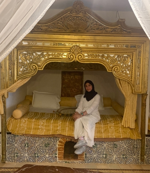       Person sitting in a luxurious room with ornate decor.
  