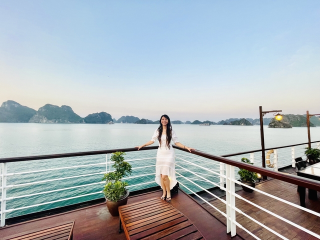 Woman enjoying a view from a boat with a bay and islands in the background.