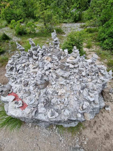       Pile of white stones in front of rocky terrain.
  