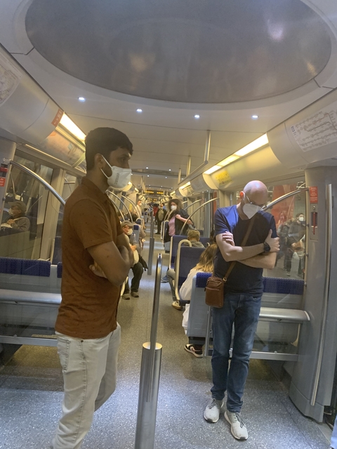 Interior of a public transport vehicle with masked passengers.