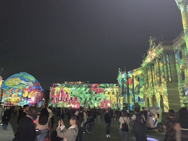       Festival with colorful light projections on buildings.
  