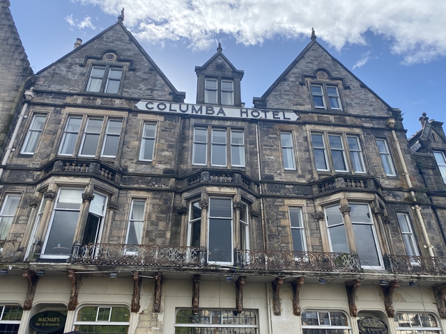      Historic hotel building with decorative facade under blue skies.
  