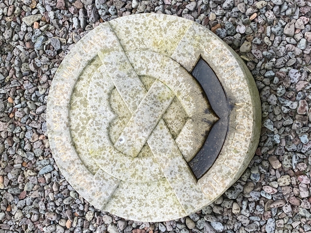       Stone carving on gravel surface.
  