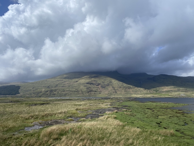       Expansive landscape with low clouds over hills.
  