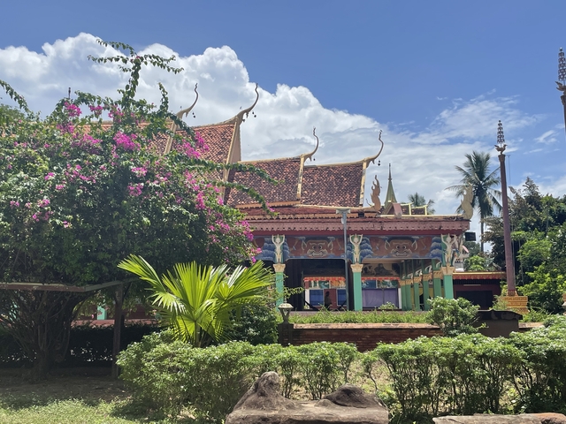       Asian temple with vibrant colors and floral foreground.
  