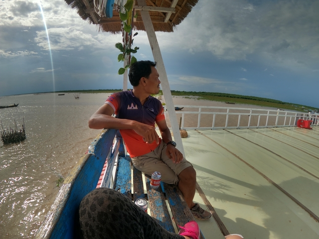       Man on a boat with cloudy sky.
  