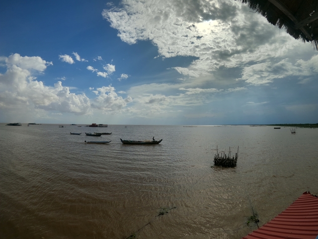      River view with boats and cloudy sky.
  