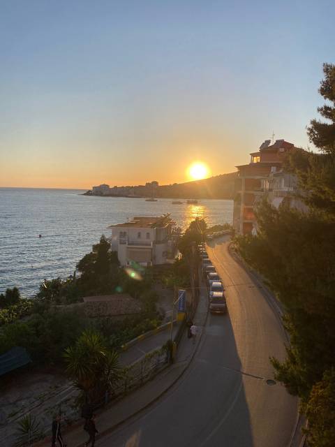 A sunset view over a body of water with buildings along the shore.
