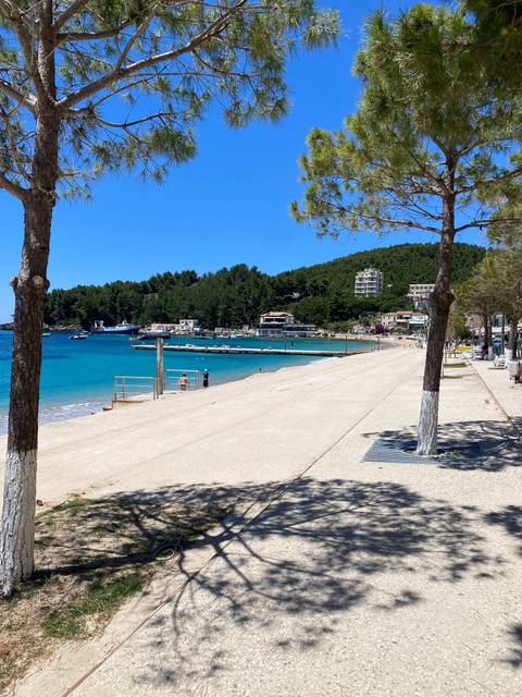       A beach area with people and clear blue water.
  
