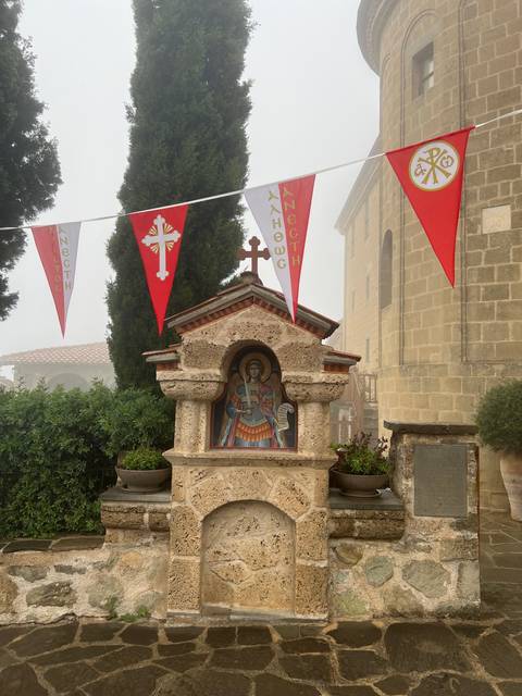 Religious monument with flags and trees.