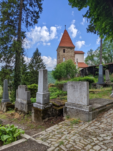 Old cemetery with gravestones and a small building.