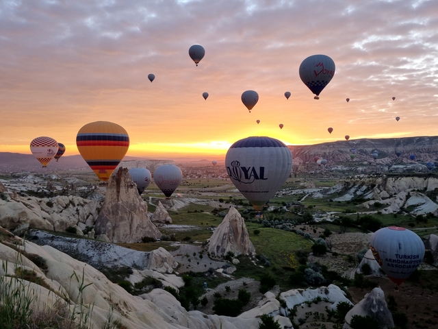       Hot air balloons flying over Cappadocia during sunrise.
  