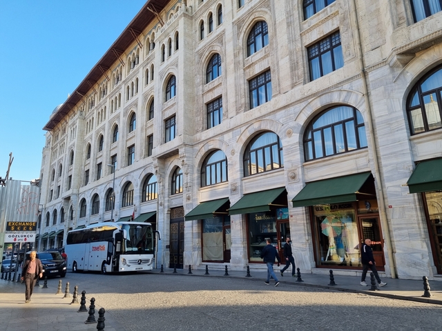       Historic building with arched windows in a city street.
  