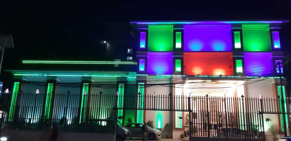       A building illuminated at night with colorful lights.
  