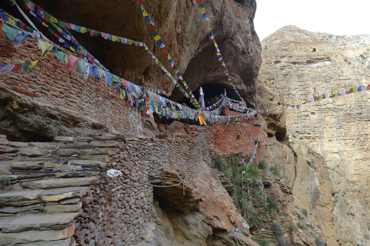 Rocky mountain path with colorful prayer flags.