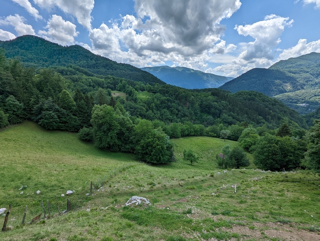 Green fields and forests with rolling hills in the background