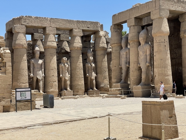 Ancient temple ruins with large statues and columns.