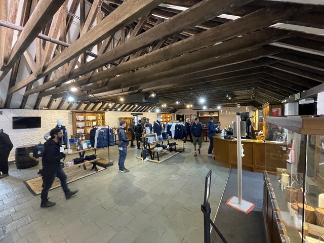 Interior of a distillery with visitors and displays.