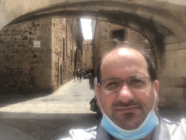 Selfie of a man with ancient stone buildings and street.