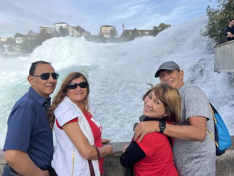       Group of people in front of large waterfall.
  