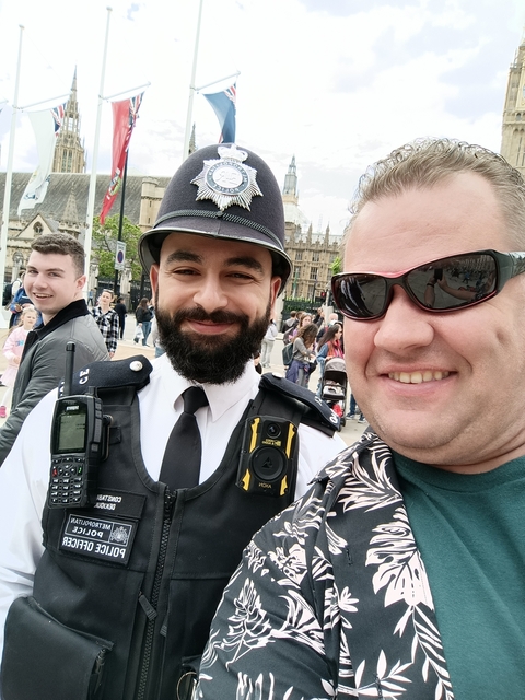 A group photo with a police officer and tourists.