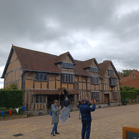 A historical house with tourists in front of it.