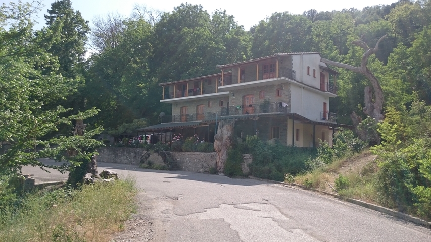       A building surrounded by trees on a rural road.
  