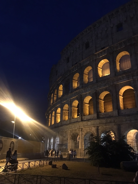 Night view of the Colosseum with lit arches.