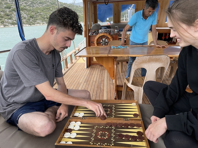 Two people playing a board game on a boat.