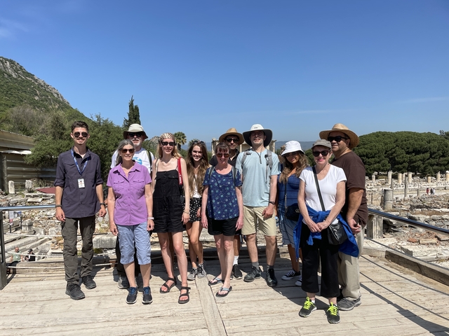Tour group posing in front of ancient ruins.