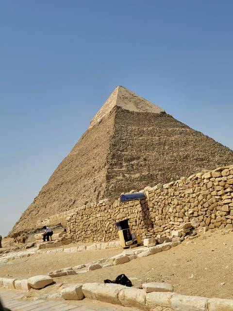 Close-up view of a large pyramid made of limestone blocks.