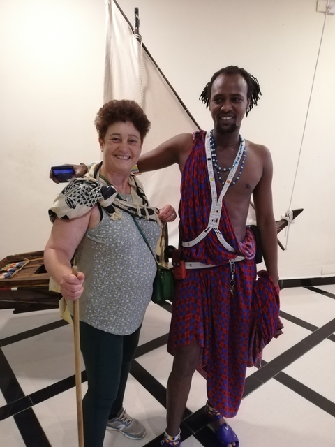 Two people posing indoors, one wearing Masai garments.