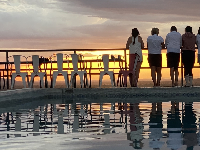 People watching the sunset by a pool