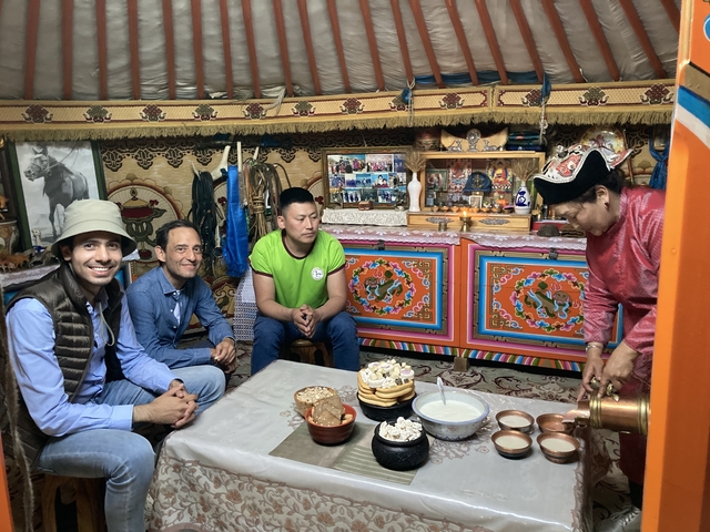       Inside a yurt with people seated around a table
  