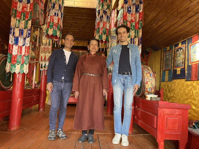       People standing inside a traditional Mongolian home
  