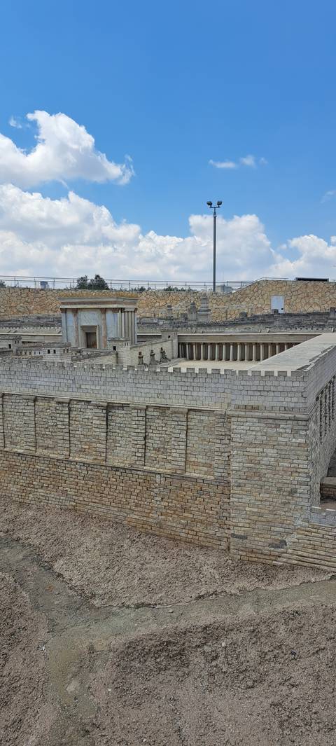 Stone building with a modern structure on a hill.