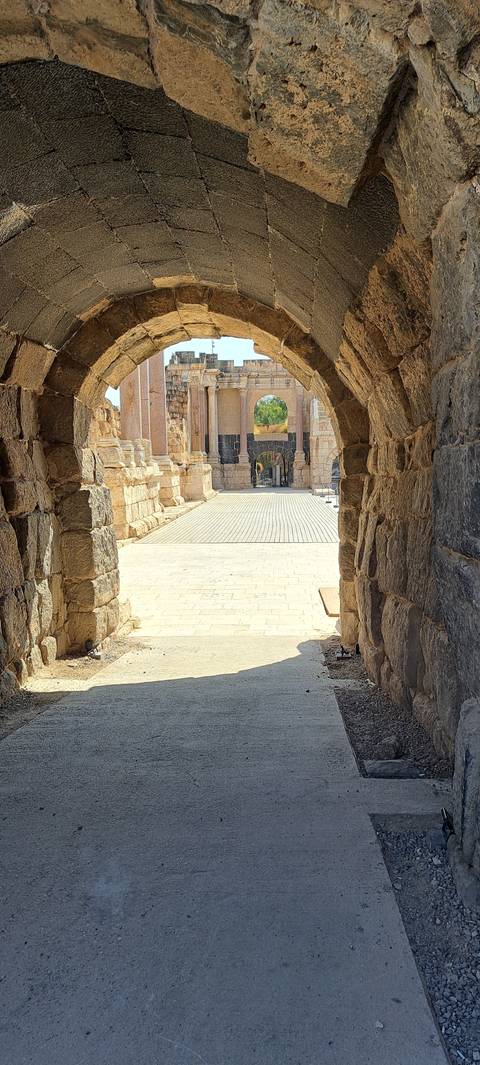 Ancient stone archway leading to a bright courtyard.