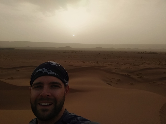       Person in the desert with sun setting.
  