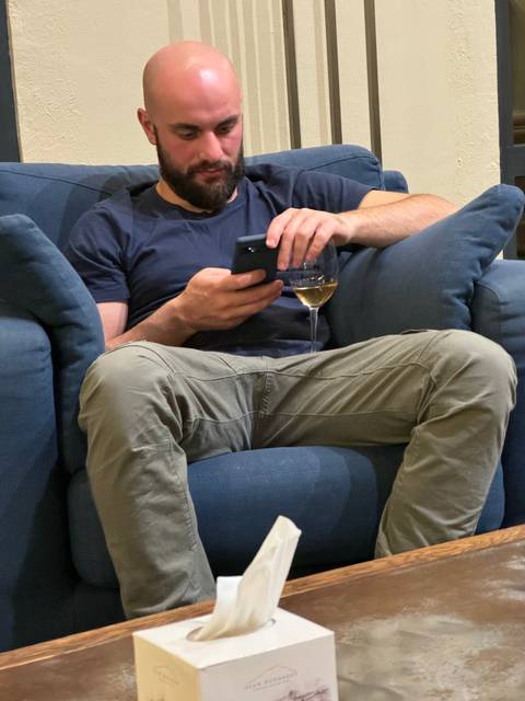 Person sitting on a couch using a smartphone.