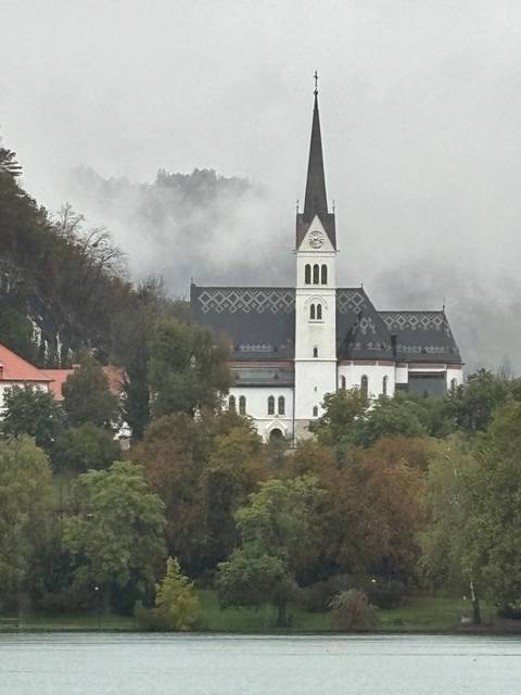 A distant view of a church by the lake.