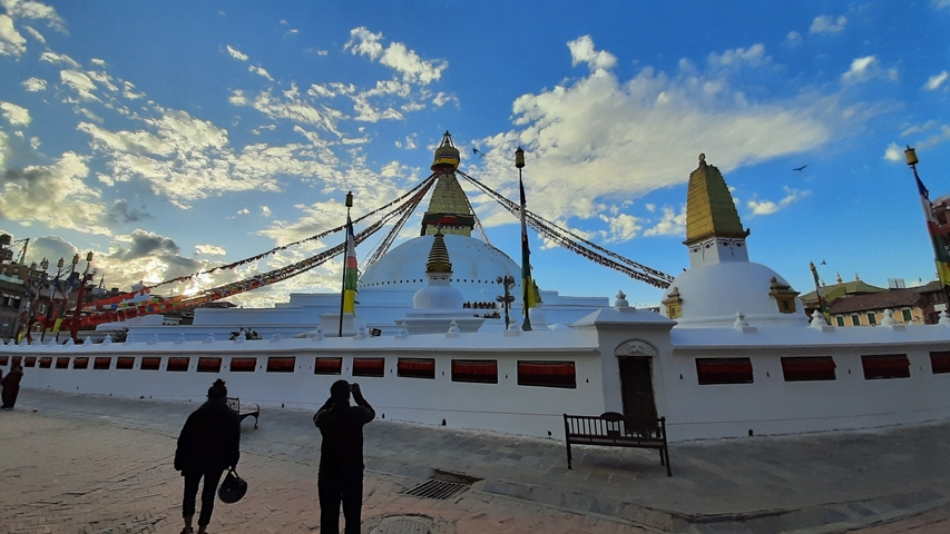       White stupa with prayer flags in a square.
  