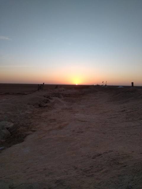 Desert sunset with silhouette of people.